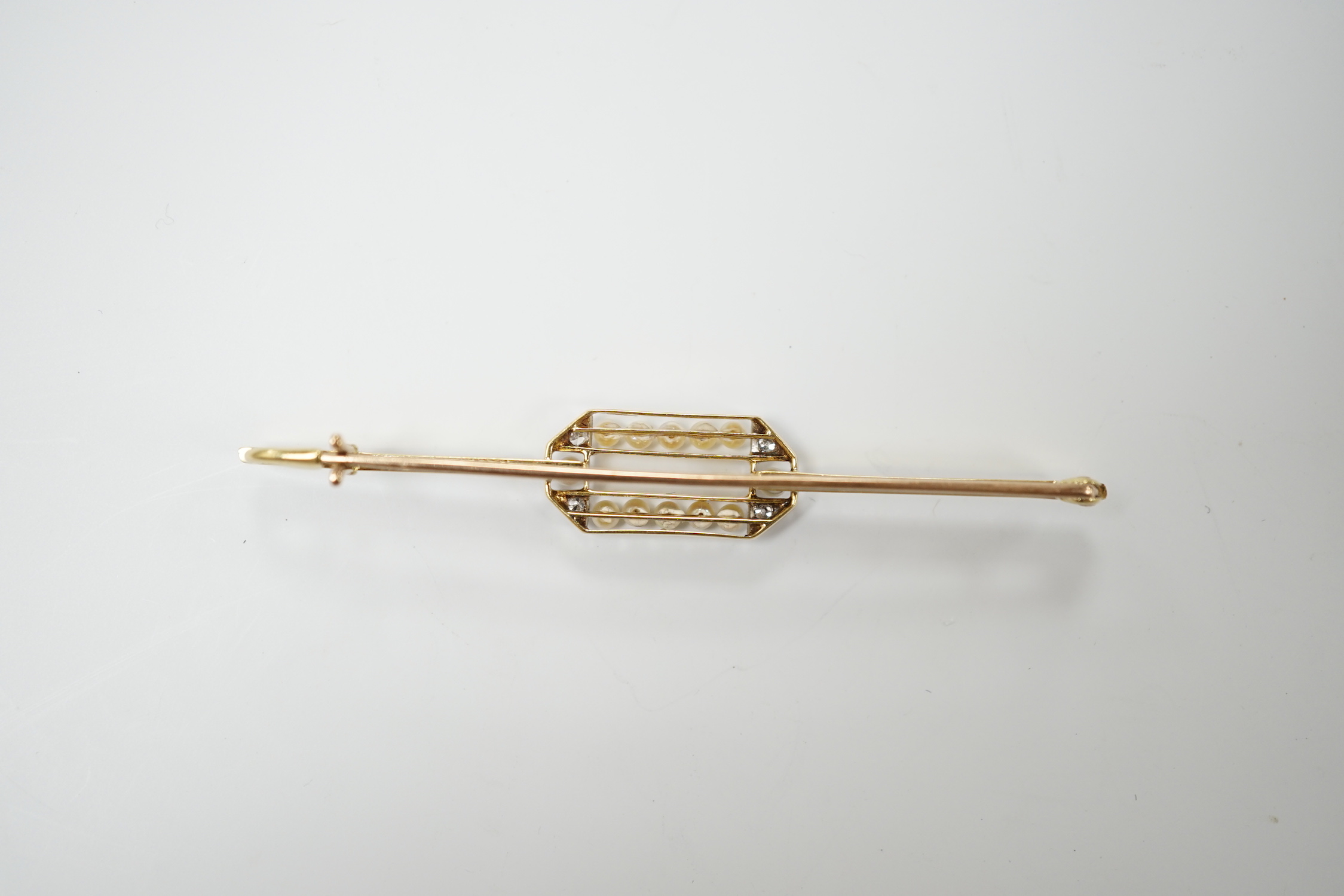 A Belle Epoque 15ct, diamond and seed pearl set bar brooch, 63mm, gross weight 3.9 grams.